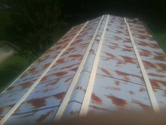 Rusted metal roof panels with new wood purlins before replacement — Storm Damage Roof Repair in Saint Joseph by Roofing Brothers
